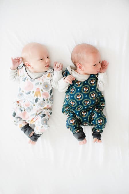 Zwillinge von oben auf dem Bett liegend