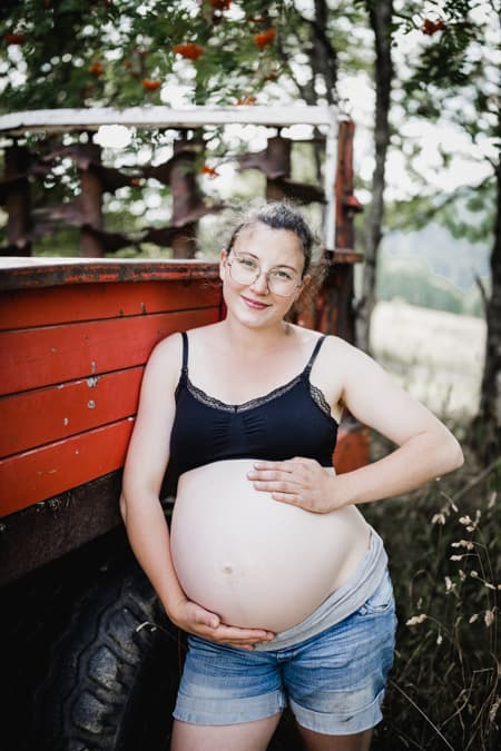 Schwangere Frau vor rotem Anhänger