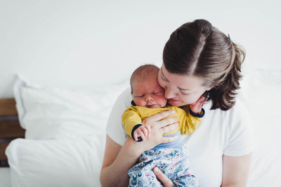 Mutter kuschelt mit ihrem Baby dicht an ihrem Gesicht
