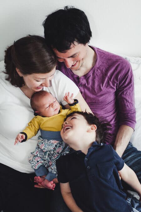 Familie eng beieinander schauen alle auf das Neugeborene