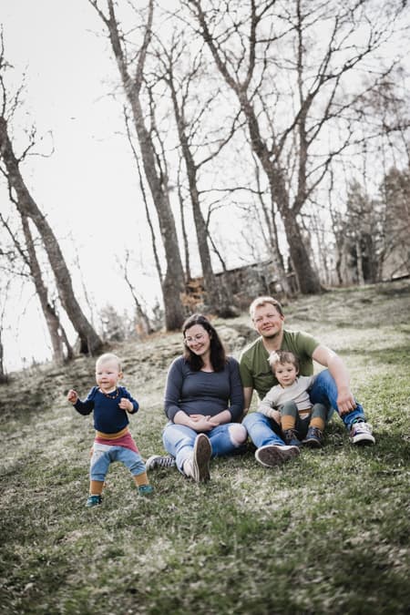 Familie sitzt auf einer Wiese