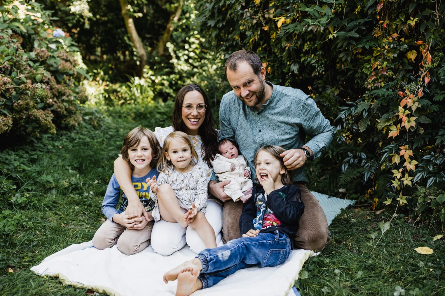 Familie auf einer Decke im Garten