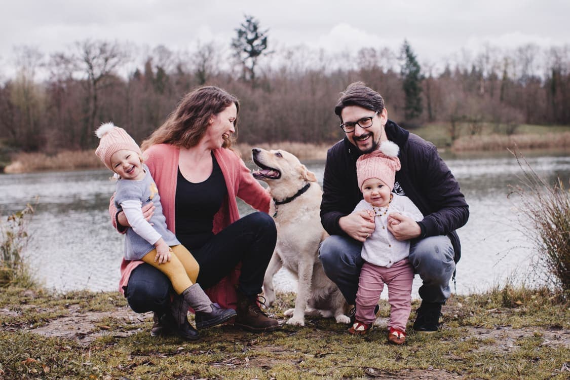 Familie mit Kindern und Hund vor einem See