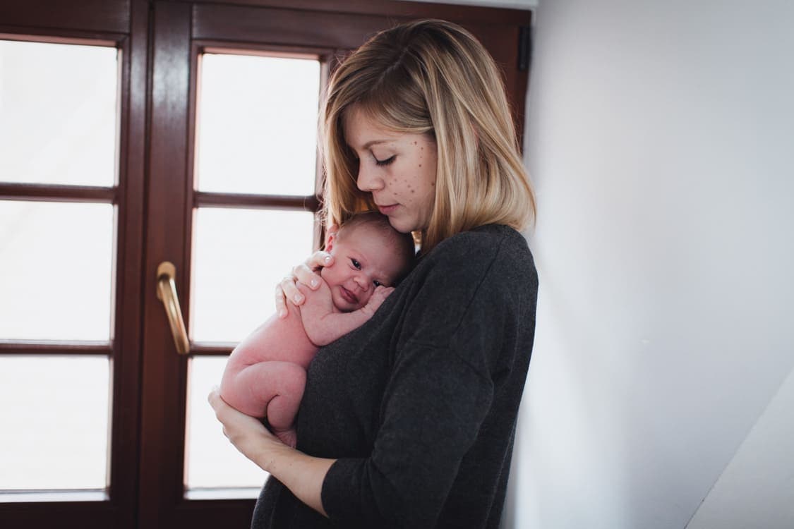Nackiges Neugeborenes bei Mama auf dem Arm