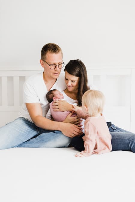 Familie mit Baby auf dem Bett