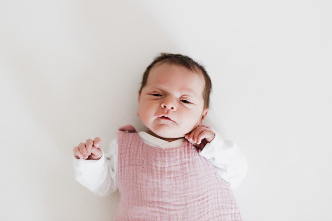 Neugeborenes liegt auf dem Bett