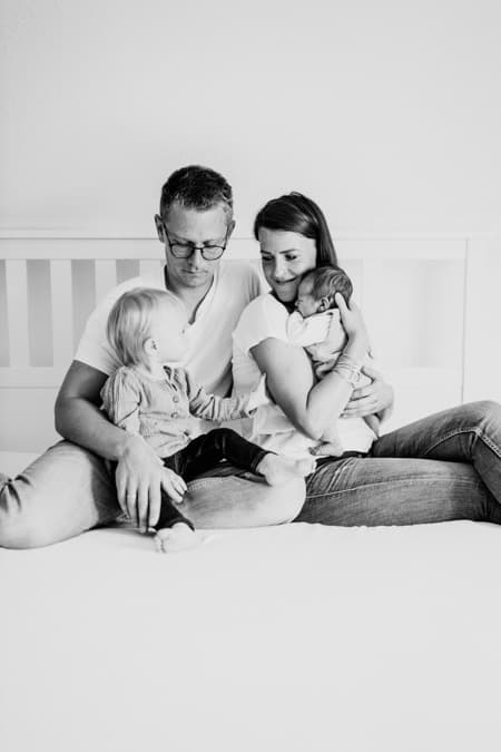 Familie mikt Kindern sitzt auf dem Bett