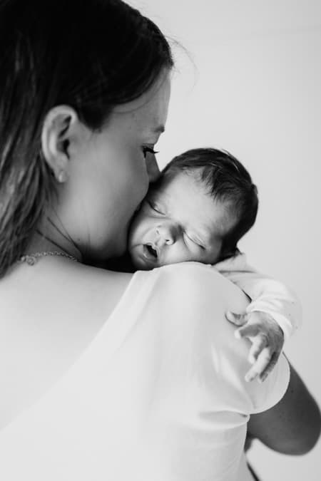 Mutter kuschelt mit Baby auf dem Arm