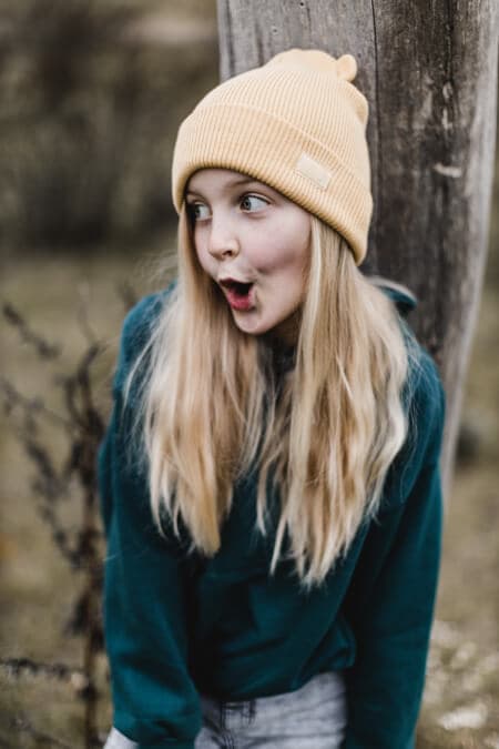 Mädchen mit gelben Mütze albert herum