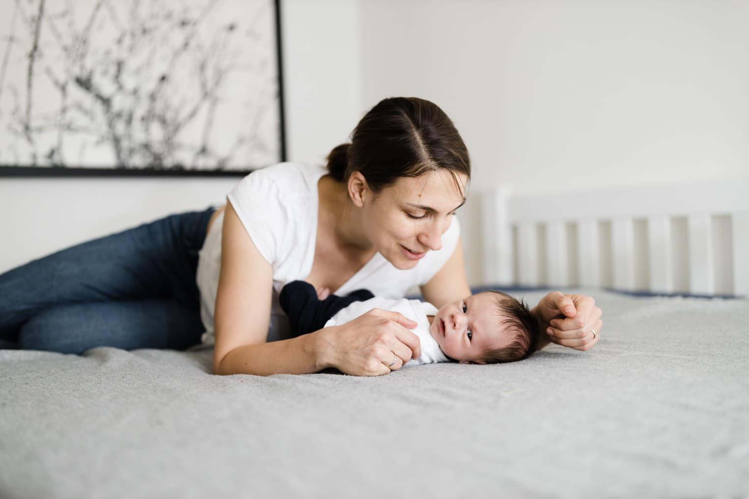 Mutter liegt mit ihrem Baby auf dem Bett