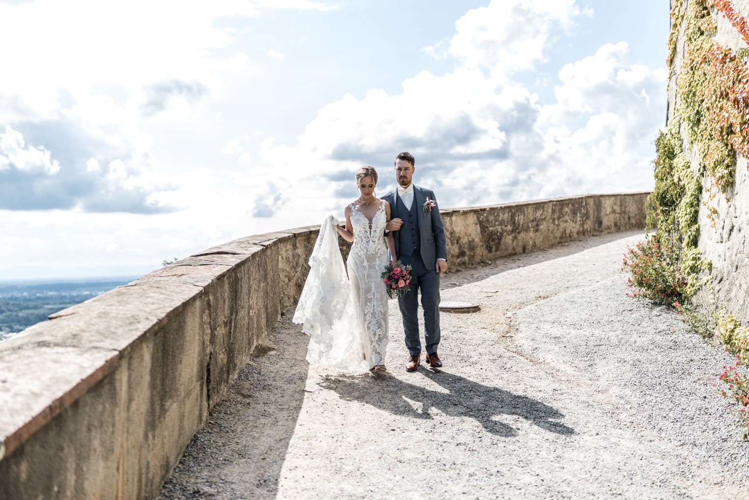 Brautpaar läuft einen Weg entlan