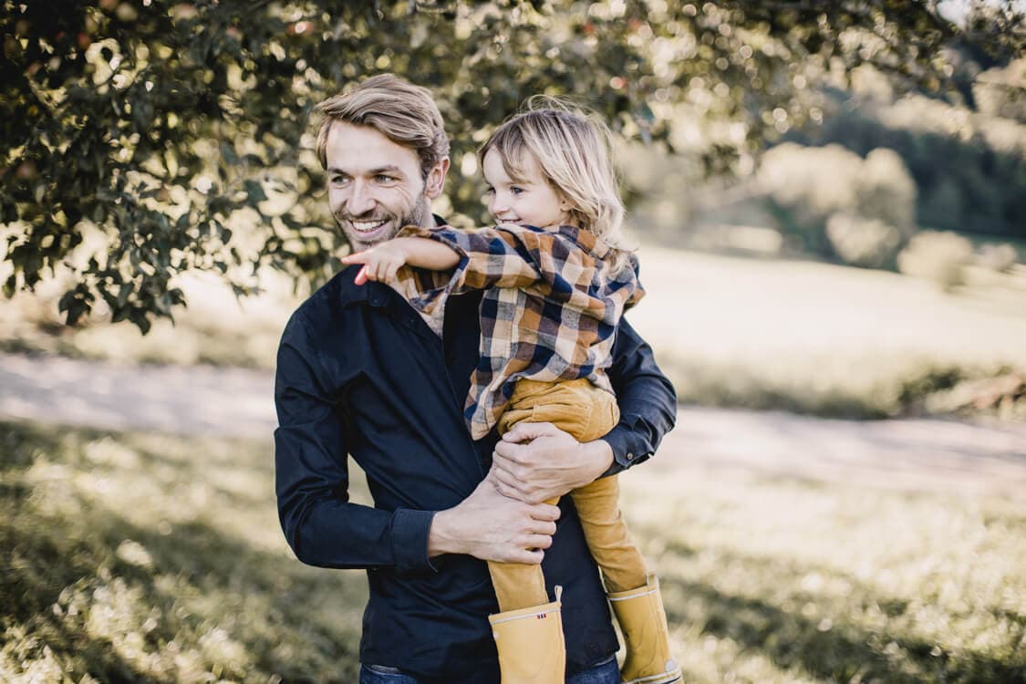 Vater hält seinen Sohn auf dem Arm der auf etwas zeigt