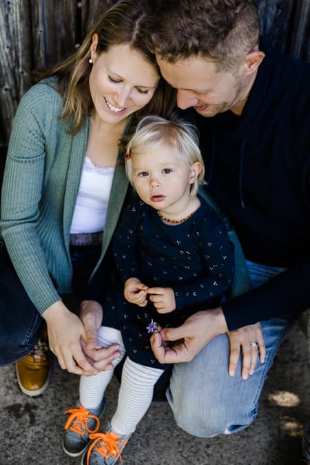 Kind sitzt bei den Eltern auf dem Schoß