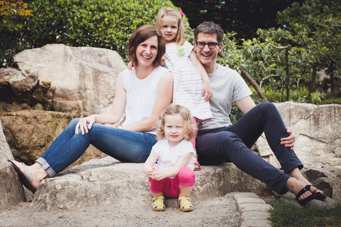 Familie sitzt auf Felsen