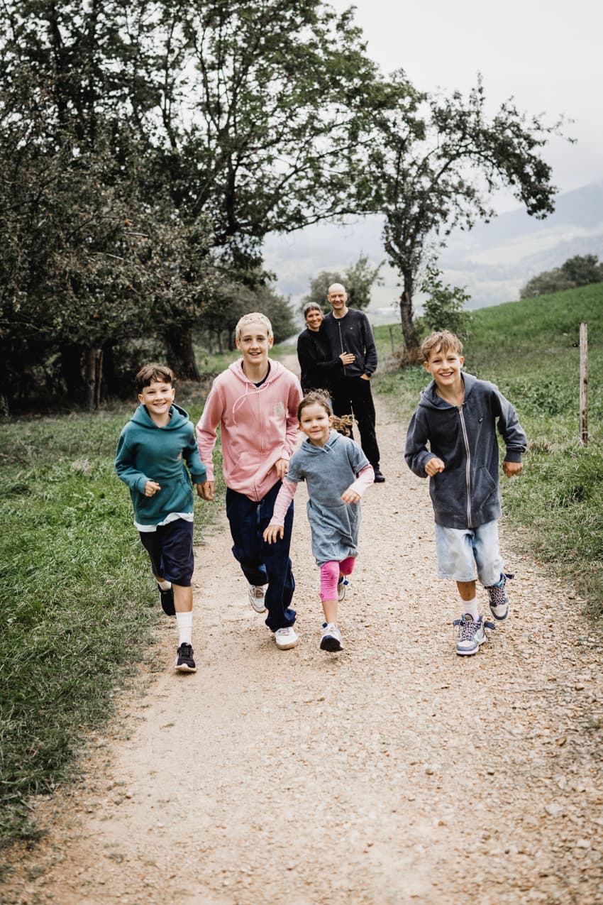 Familie rennt einen Weg entlang