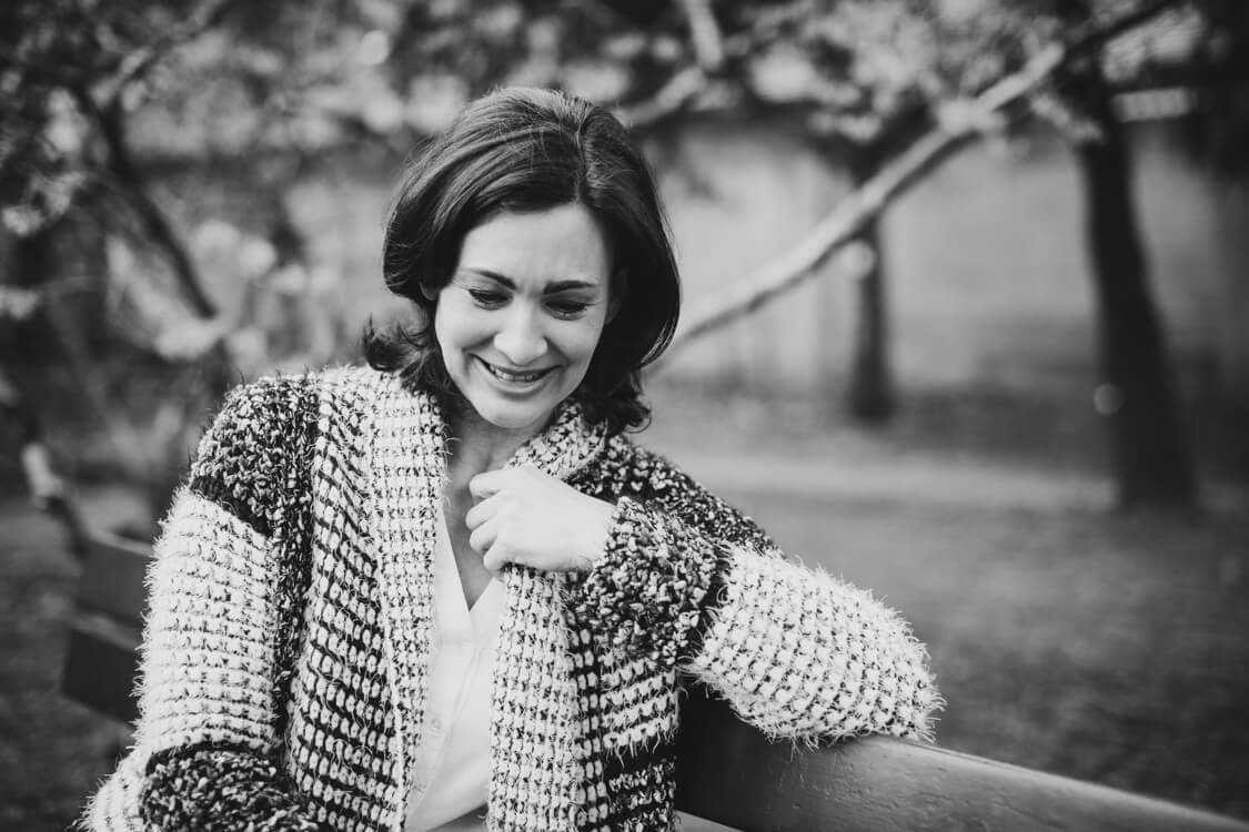 Frau sitzt auf einer Bank und lacht