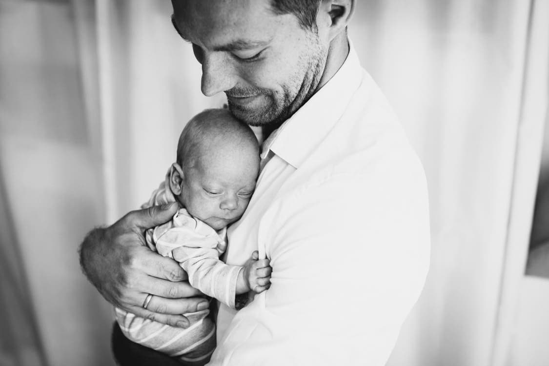 Papa kuschelt mit Baby auf dem Arm