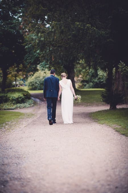 Brautpaar von hinten zu sehen, laufen einen Weg entlang