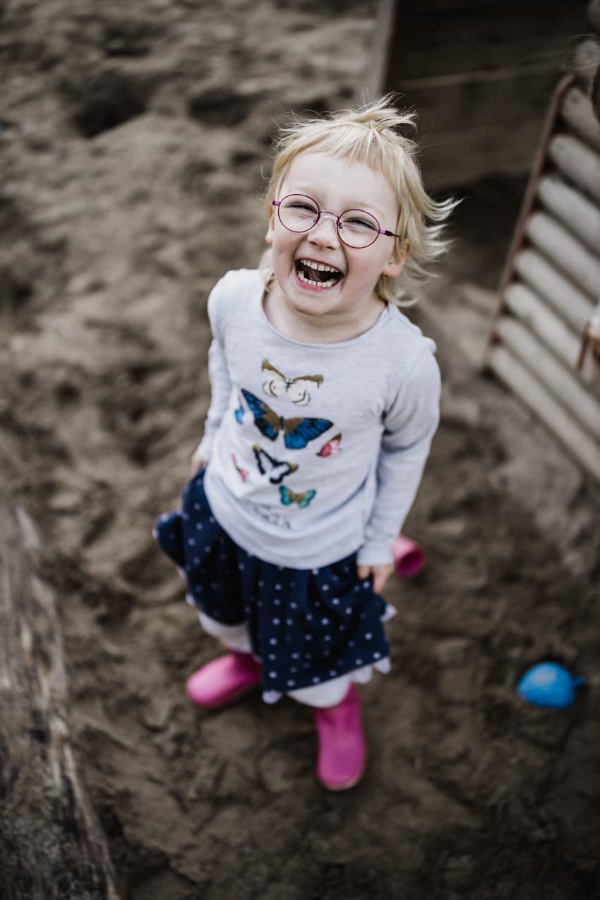 Mädchen im Sandkasten lacht