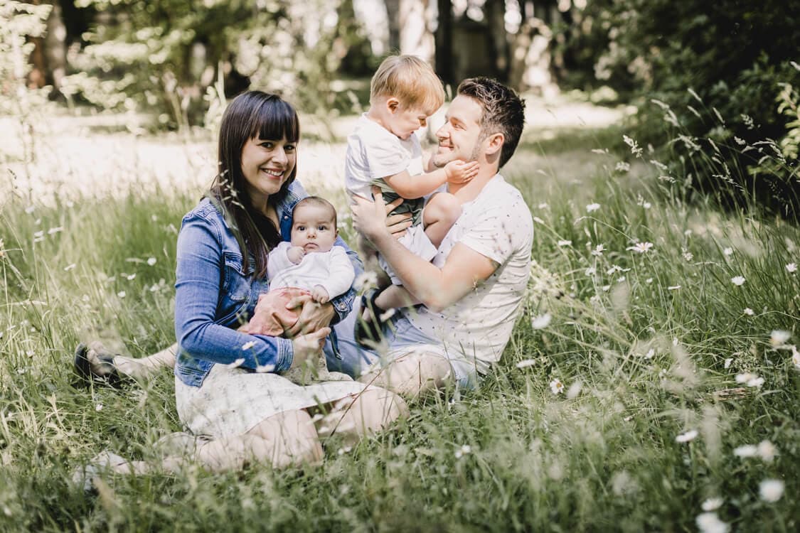 Familie tollt auf einer Wiese rum