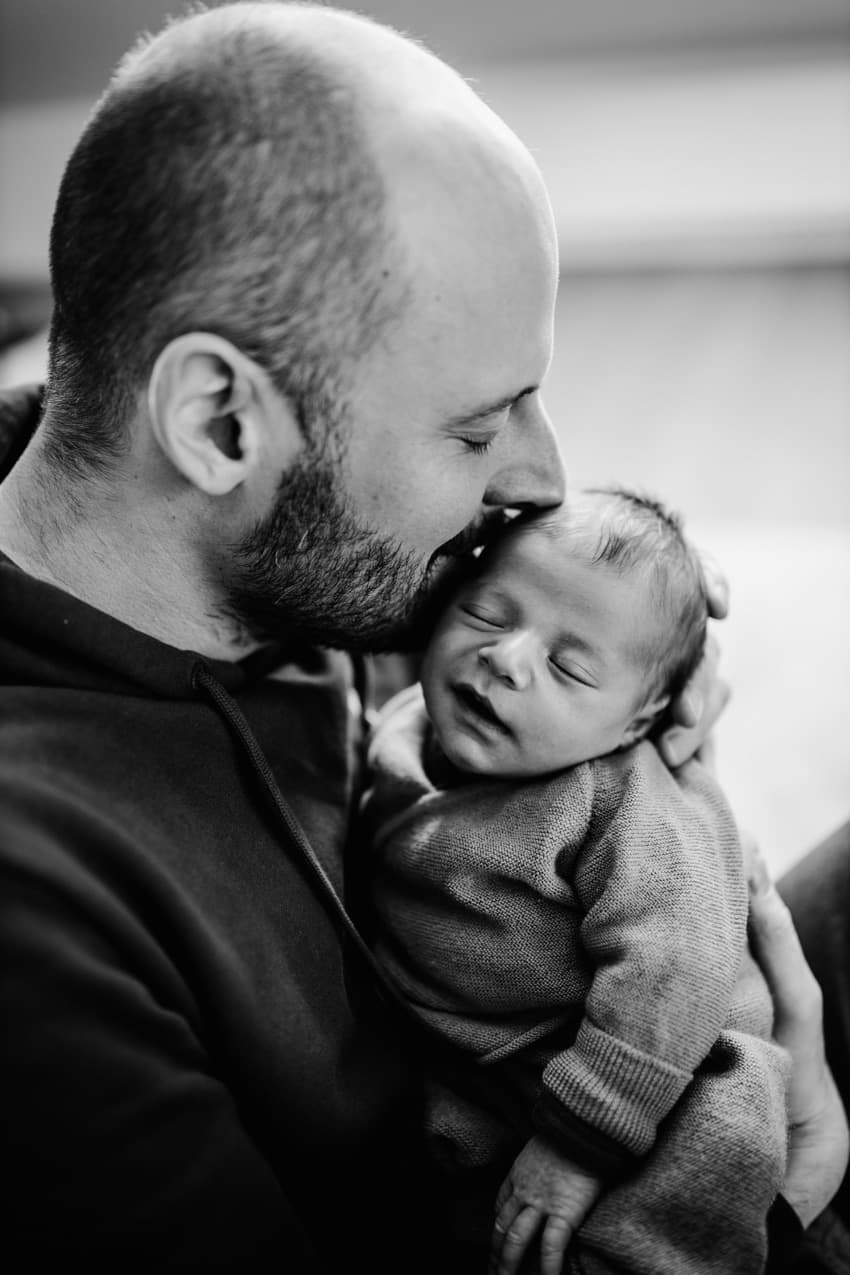 Vater küsst sein Baby auf die Schläfe