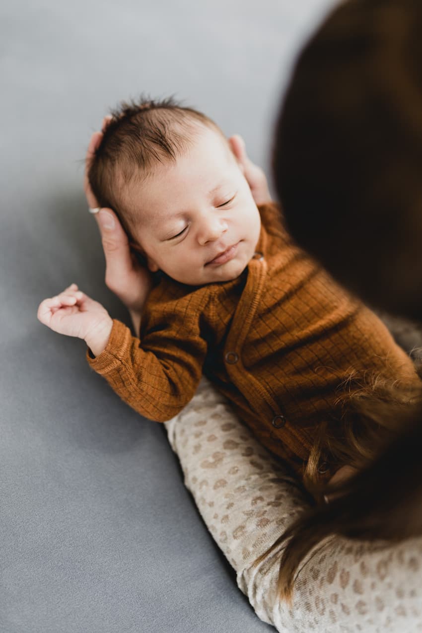 Baby liegt in den Händen der Mutter