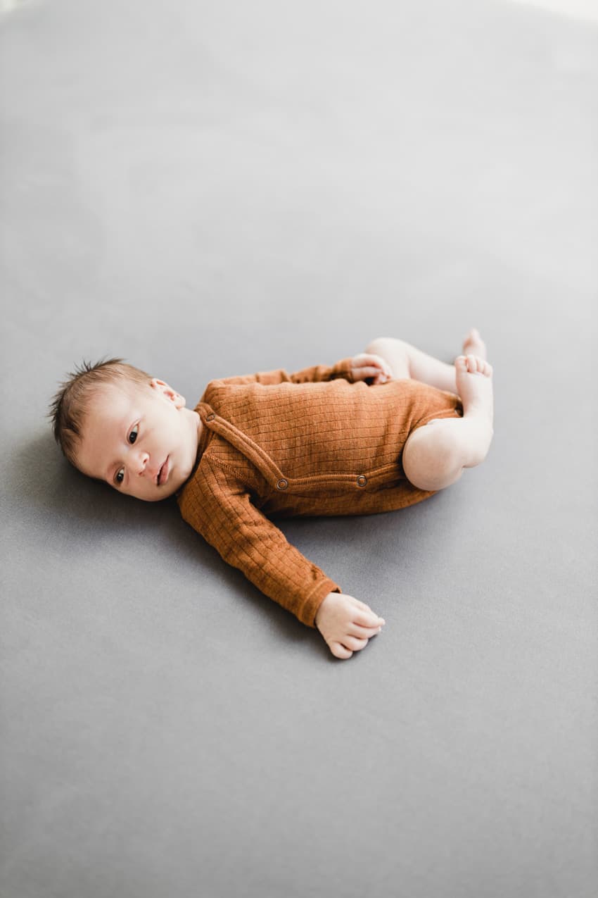 Baby liegt auf einem Bett