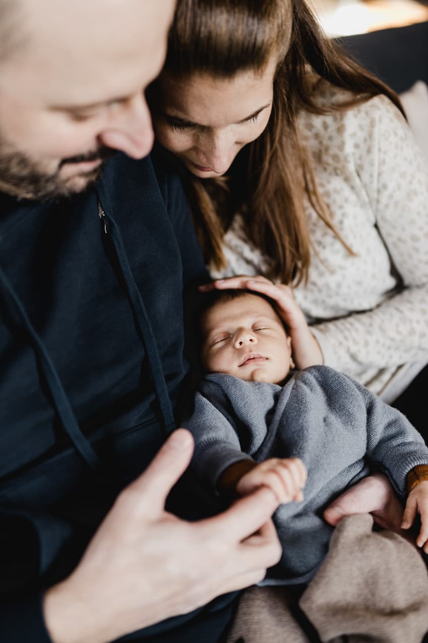 Eltern halten ihr Baby in den Händen