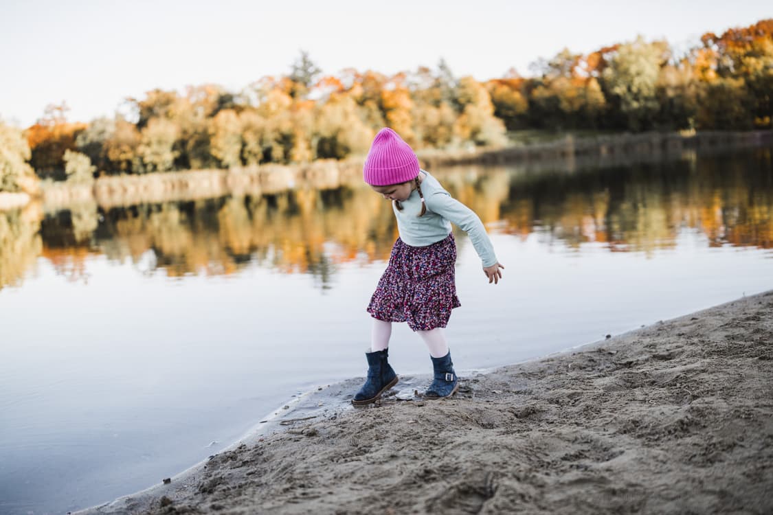 Maedchen am See mit Fuß im Wasser