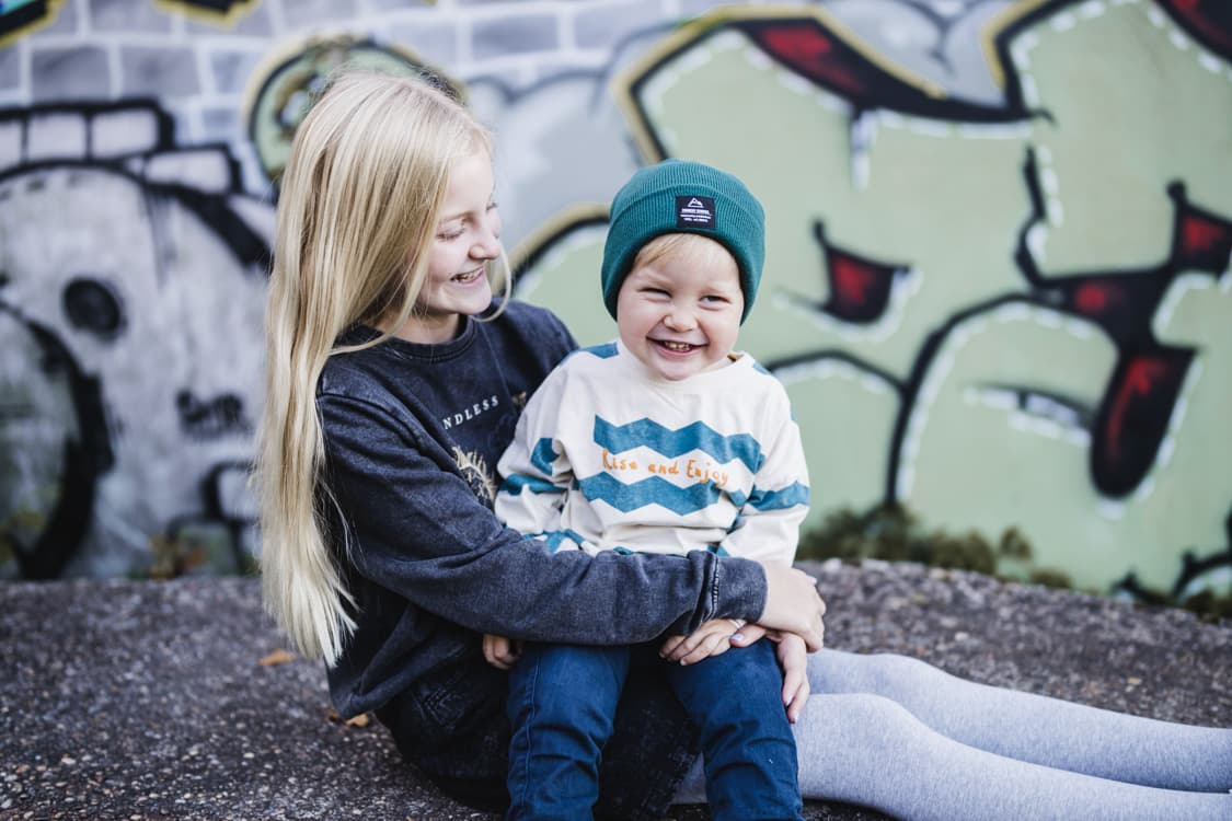Maedchen mit Junge vor einem Graffiti