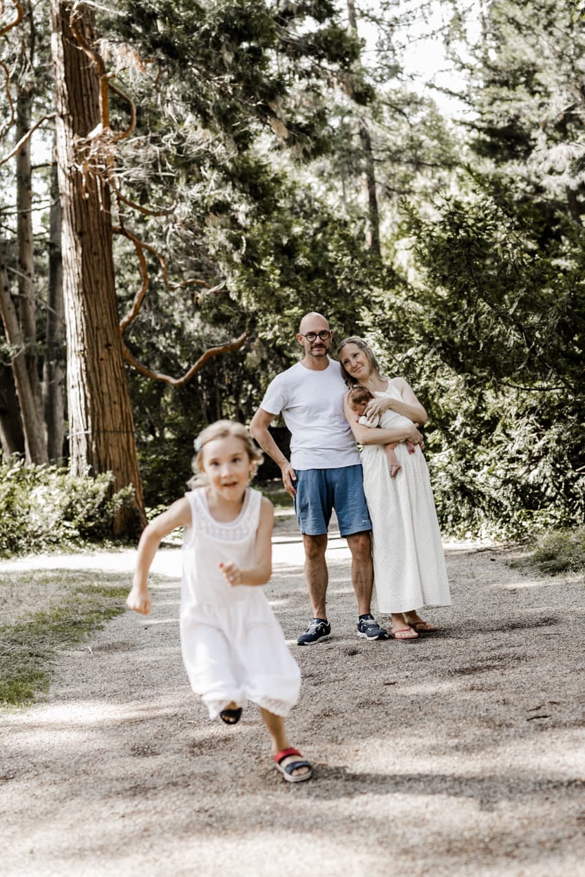 Mädchen rennt und ihre Familie ist im Hintergrund zu sehen