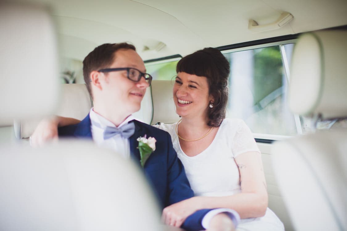 Brautpaar schaut sich an auf der Rückbank vom Bulli