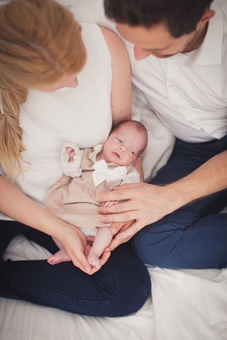 Blick von oben auf Neubeborenes das bei den Elten auf dem Schoß liegt