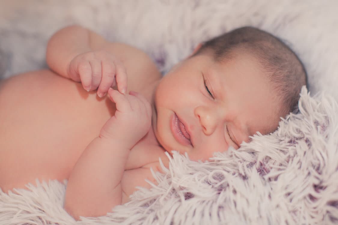 Baby liegt auf kuschligem Fell