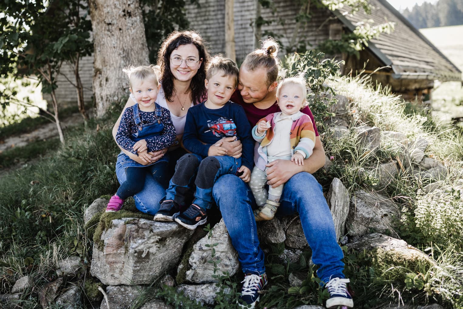 Familie sitzt auf einem Felsen