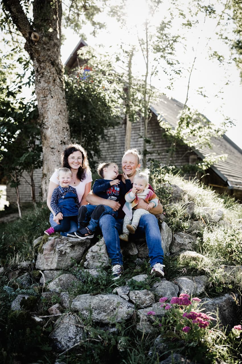 Familie sitzt auf einem Felsen