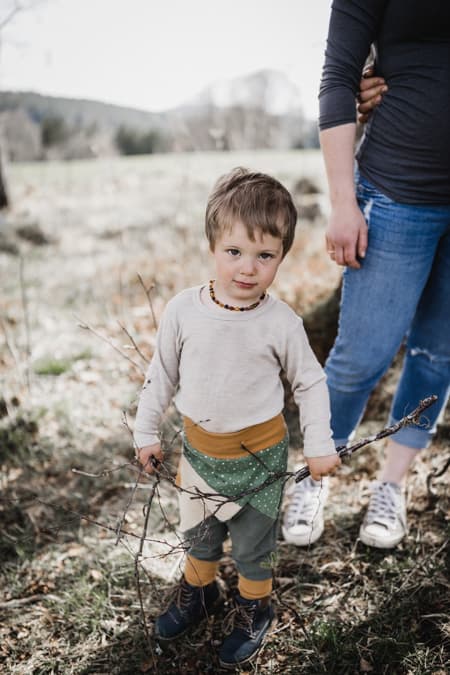 Kleiner Junge mit Stoecken in den Haenden