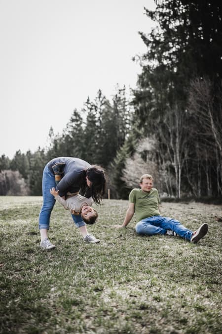Eltern toben mit Kindern auf einer Wiese