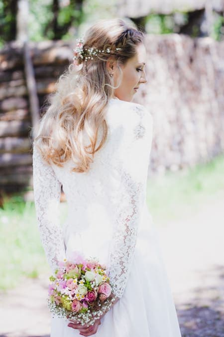 Braut hält Brautstrauß hinter dem Rücken