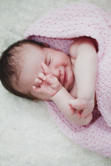 Baby reibt sich verschlafen die Augen