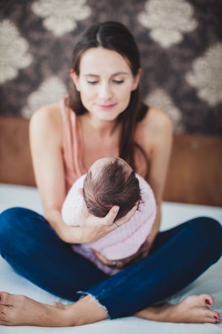 Mutter hält ihr in eine Decke eingewickeltes Baby im Arm