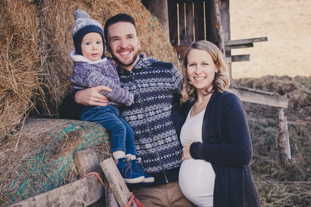 Familie von Strohballen. Frau mit Babybauch.