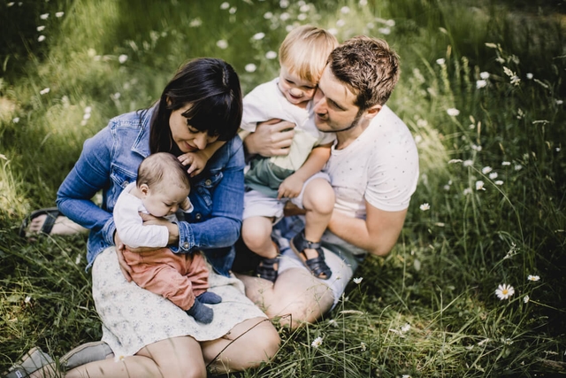 Familie von oben auf einer Wiese sitzend