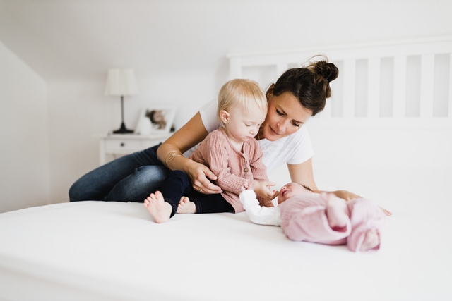 Mutter mit Kindern auf dem Bett