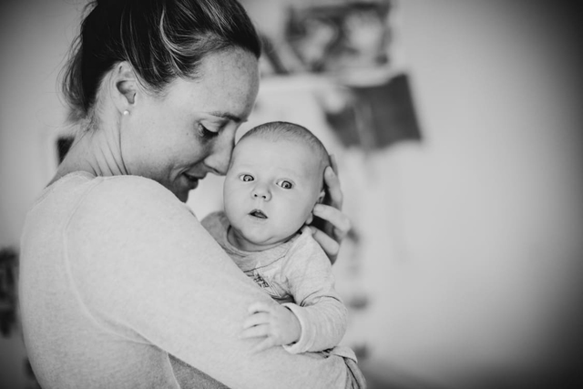 Mama kuschelt mit Baby Tochter auf dem Arm