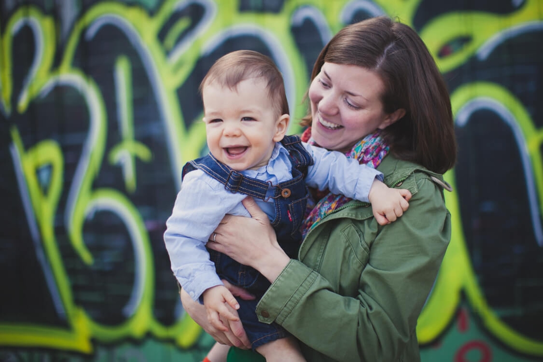 Mutter und kleiner Sohn mit Grafiti im Hintergrund