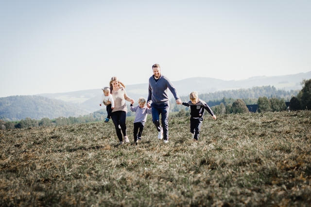 Familie rennt ueber Wiese