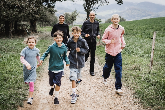 Familie rennt einen Weg entlang