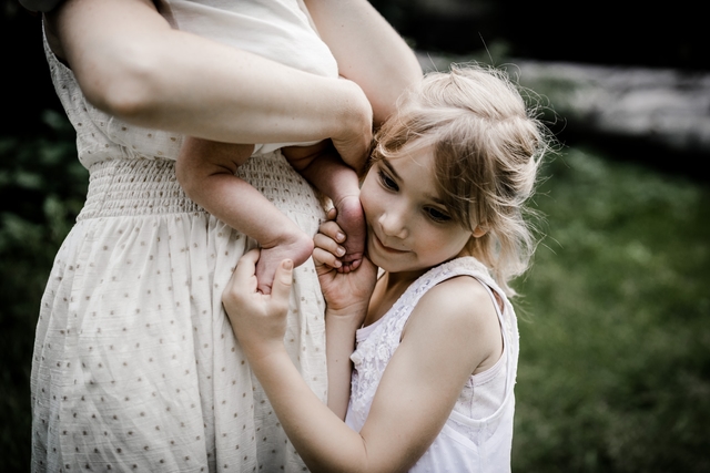 Babyfüße in den Händen der Schwester