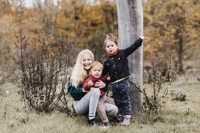 Foto von drei Kindern auf einer Wiese schauen in die Kamera